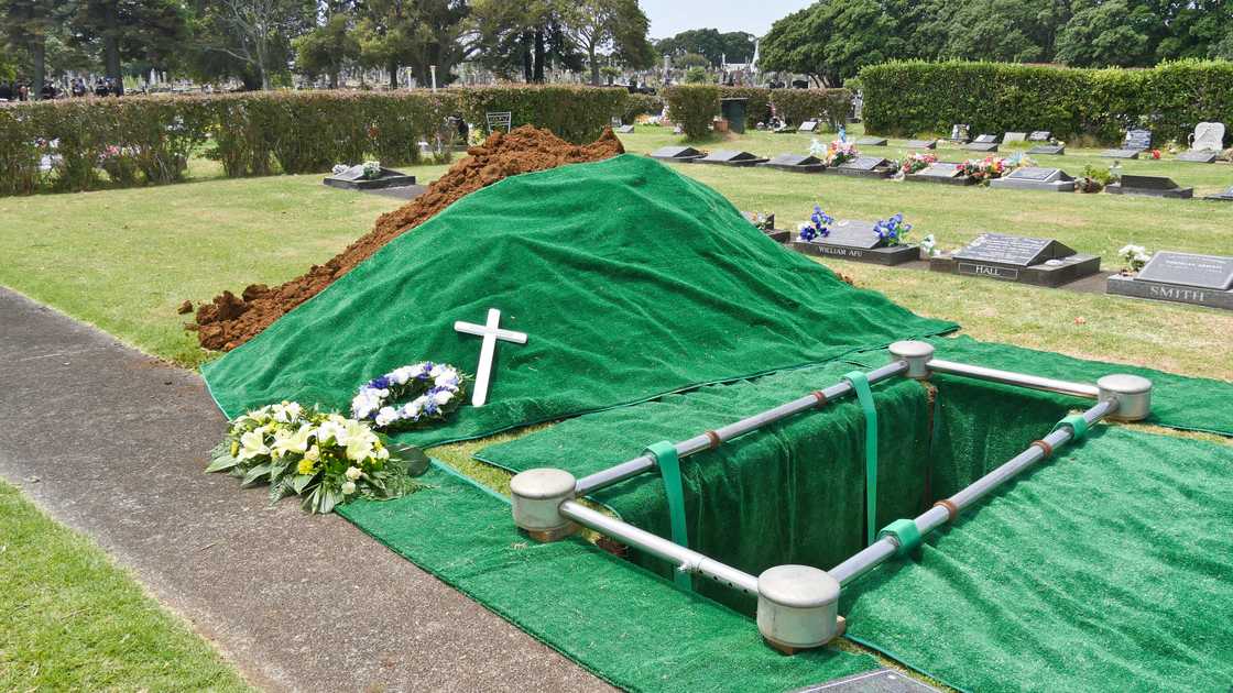 Freshly prepared burial site with green-lined grave.