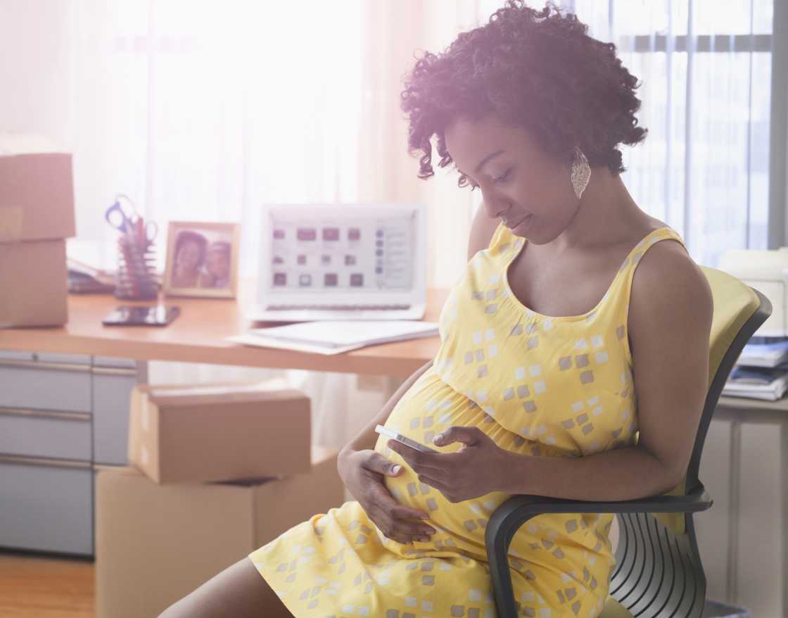 Photo of pregnant woman looking on her phone