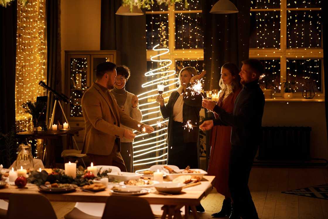 A family celebrates Christmas with burning sparklers in hand.