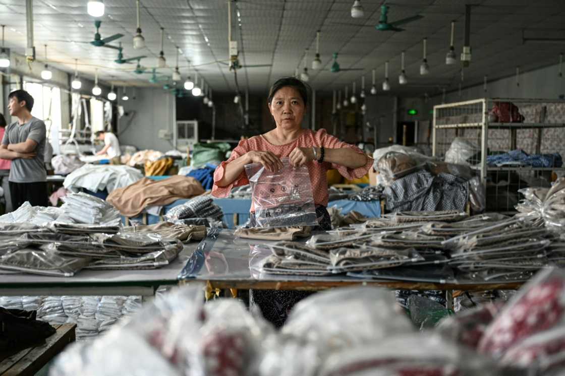 An employee packages garments for the online Chinese e-commerce company Temu at a clothing factory in Guangzhou An employee packages garments for the online Chinese e-commerce company Temu at a clothing factory in Guangzhou