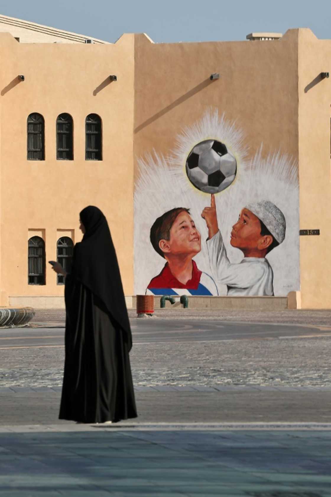 A woman walks past a mural in the Katara Cultural Village, in Qatar's capital Doha, on October 11, 2022 ahead of the FIFA 2022 football World Cup A woman walks past a mural in the Katara Cultural Village, in Qatar's capital Doha, on October 11, 2022 ahead of the FIFA 2022 football World Cup
