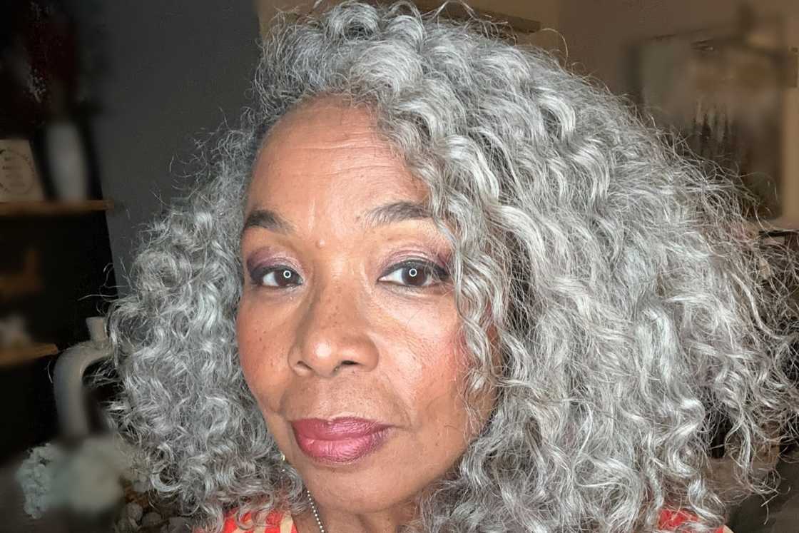 A woman rocking a curly grey hair with a side part A woman rocking a curly grey hair with a side part