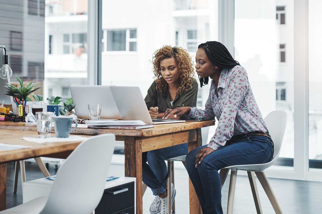 Shot of two young colleagues using a laptop Shot of two young colleagues using a laptop