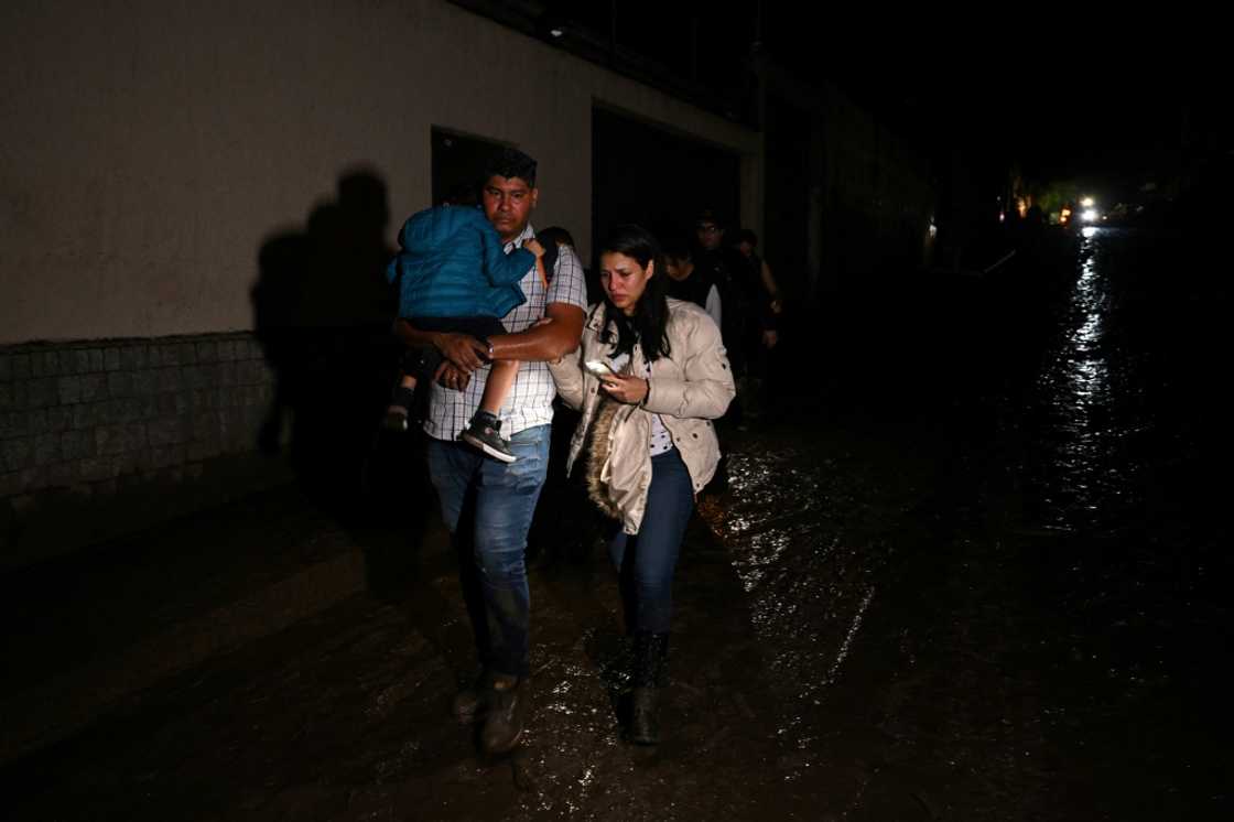 A family evacuates their home after a landslide in northern Venezuela that has left three dead