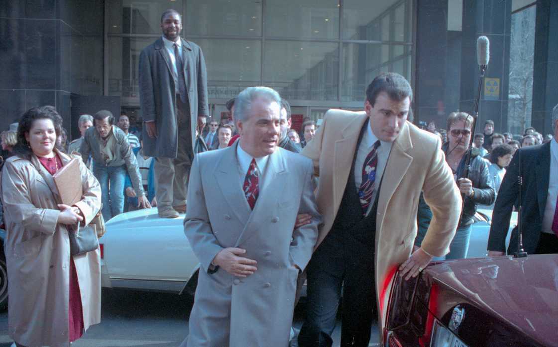 John Gotti (centre) is escorted by an unidentified man through the crowds outside court John Gotti (centre) is escorted by an unidentified man through the crowds outside court