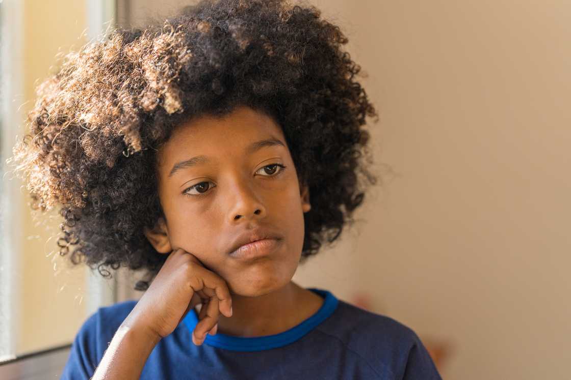 A boy with head in his hand