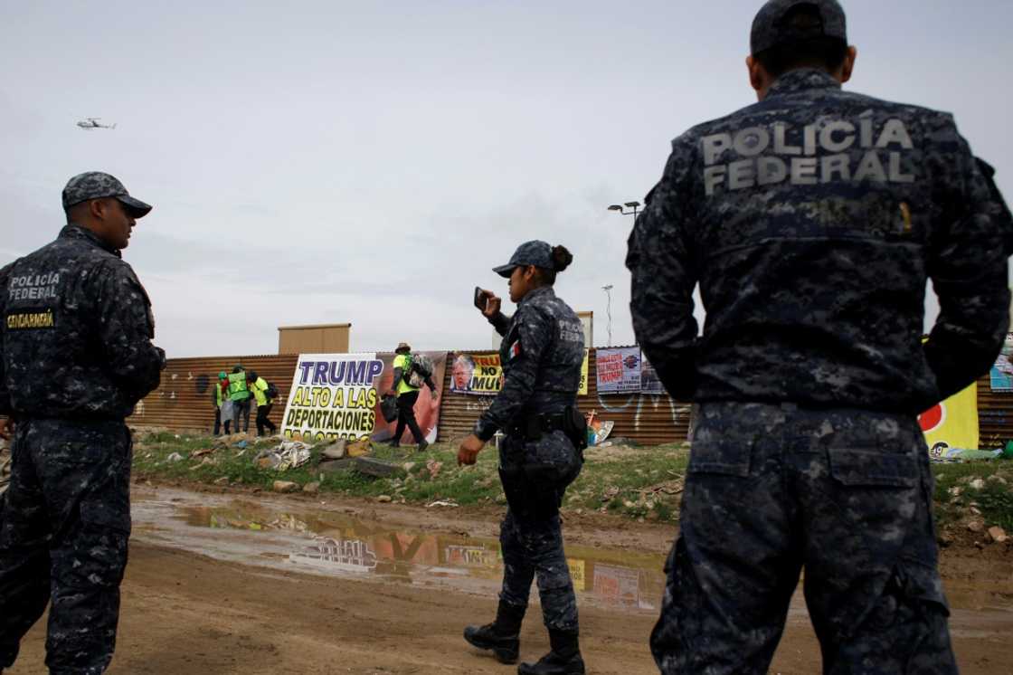 Mexican police watch a protest against US president Donald Trump's migration policies in Tijuana Mexican police watch a protest against US president Donald Trump's migration policies in Tijuana