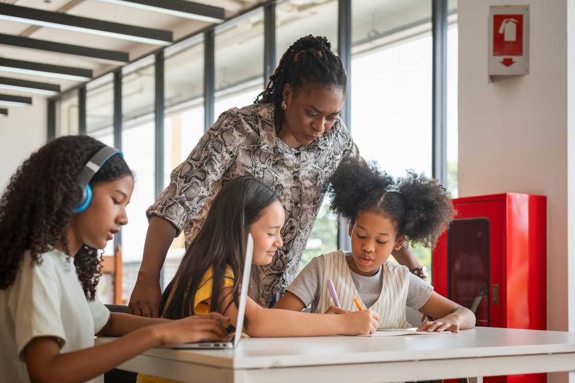 A teacher encourages pupils during quiet reflection time. A teacher encourages pupils during quiet reflection time.