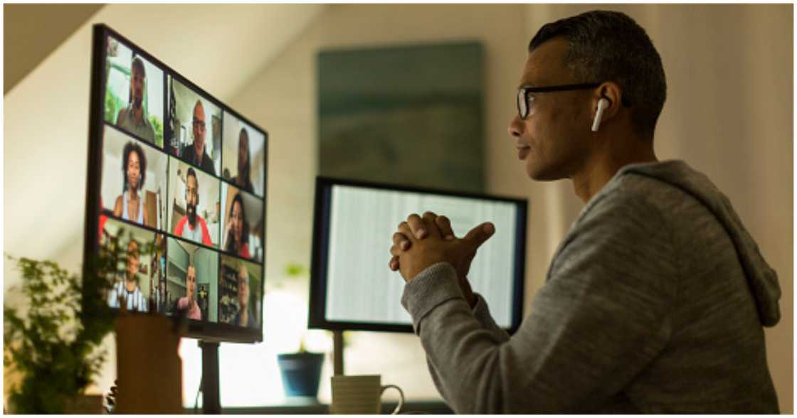 Man holds virtual work meeting from home