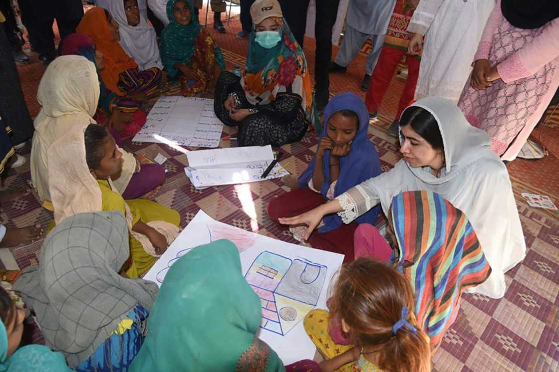 This handout picture taken and released by Chief Minister House Office of Sindh Province on October 12, 2022 shows Nobel Peace laureate Malala Yousafzai (R) speaking with flood-affected children at a makeshift school in Johi, Dadu district of Sindh province This handout picture taken and released by Chief Minister House Office of Sindh Province on October 12, 2022 shows Nobel Peace laureate Malala Yousafzai (R) speaking with flood-affected children at a makeshift school in Johi, Dadu district of Sindh province