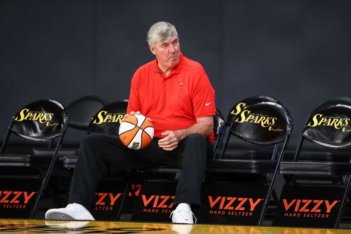 Bill Laimbeer in an orange tee holding a ball