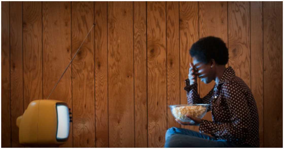 A woman is frightened as she watches television