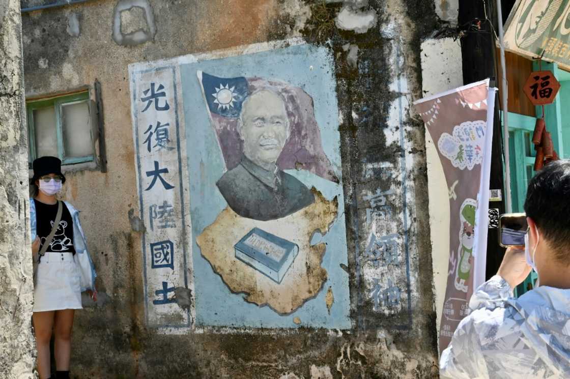 Tourists pose for pictures next to a mural of late Taiwanese president Chiang Kai-shek in Taiwan's Kinmen islands Tourists pose for pictures next to a mural of late Taiwanese president Chiang Kai-shek in Taiwan's Kinmen islands