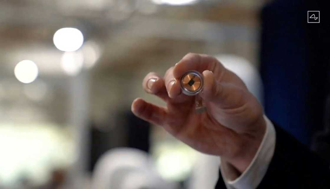 A Neuralink disk implant held by Elon Musk A Neuralink disk implant held by Elon Musk