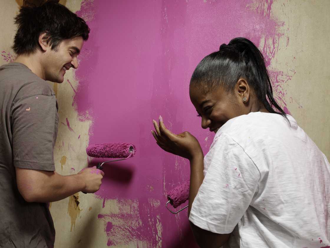 Happy couple painting a house