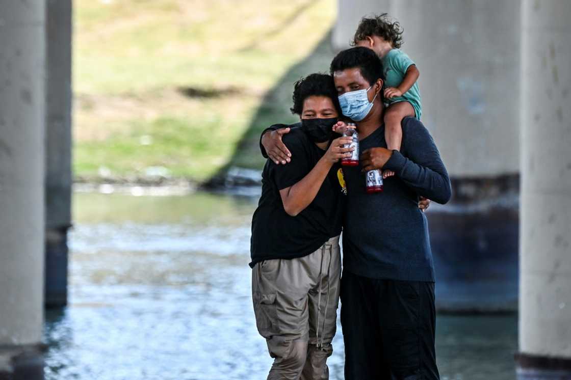 A migrant couple hug after successfully crossing the Rio Grande A migrant couple hug after successfully crossing the Rio Grande