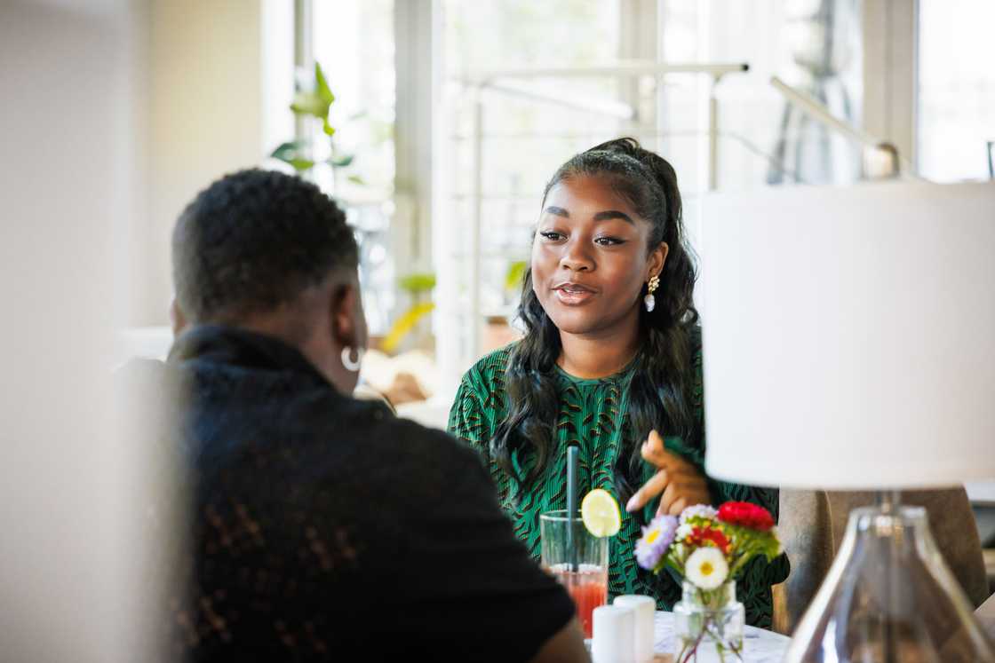 A man and woman talking over dinner