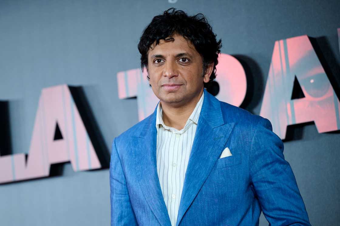 M. Night Shyamalan in a stripped shirt and blue coat M. Night Shyamalan in a stripped shirt and blue coat