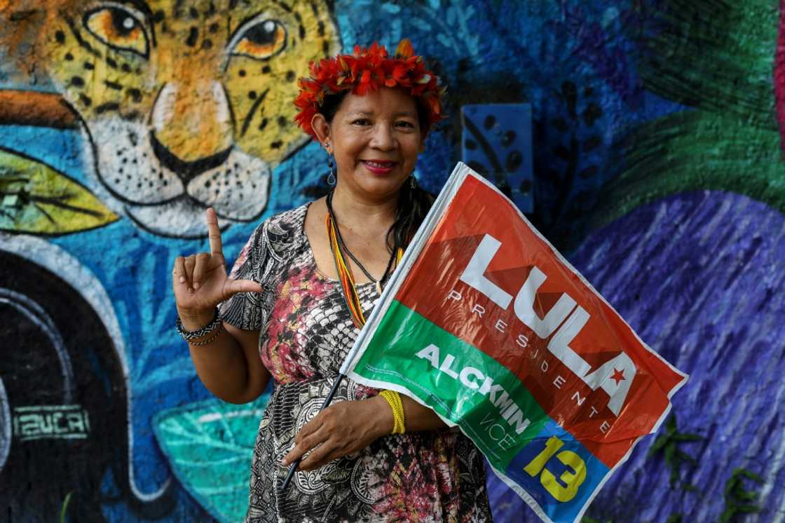 Claudia Bare, an indigenous woman from the Bare tribe, holds a flag in support of Brazil's former president Luiz Inacio Lula da Silva, who is running to hold the office again Claudia Bare, an indigenous woman from the Bare tribe, holds a flag in support of Brazil's former president Luiz Inacio Lula da Silva, who is running to hold the office again