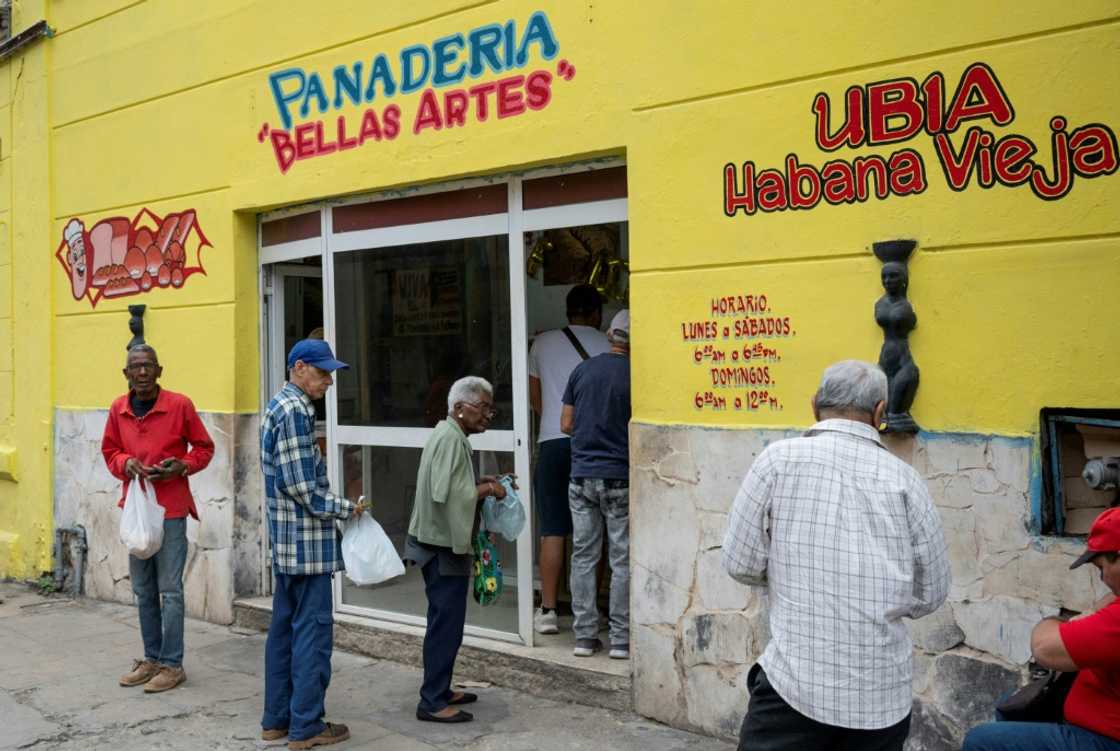 Elderly people queue to buy bread at a bakery in Havana