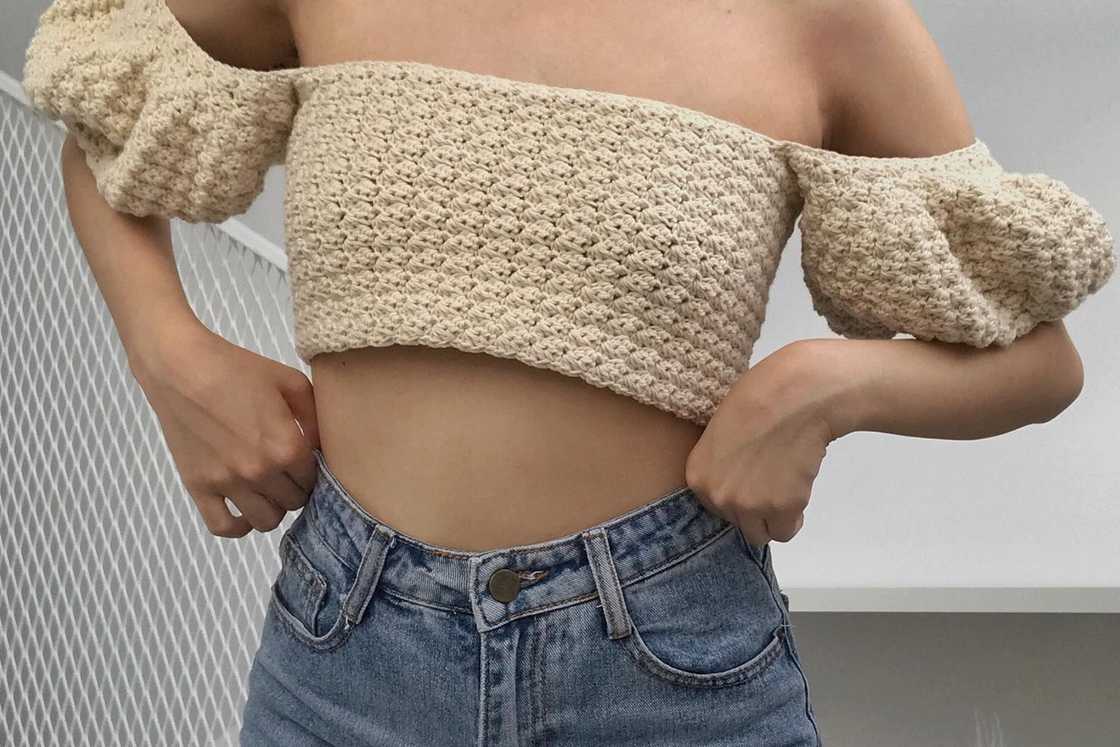 A lady is wearing a crochet crop top with a pair of jeans A lady is wearing a crochet crop top with a pair of jeans