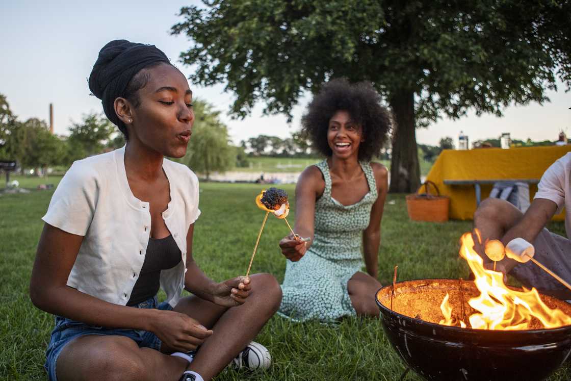 A group of young adults soaking in the sun during an afternoon picnic