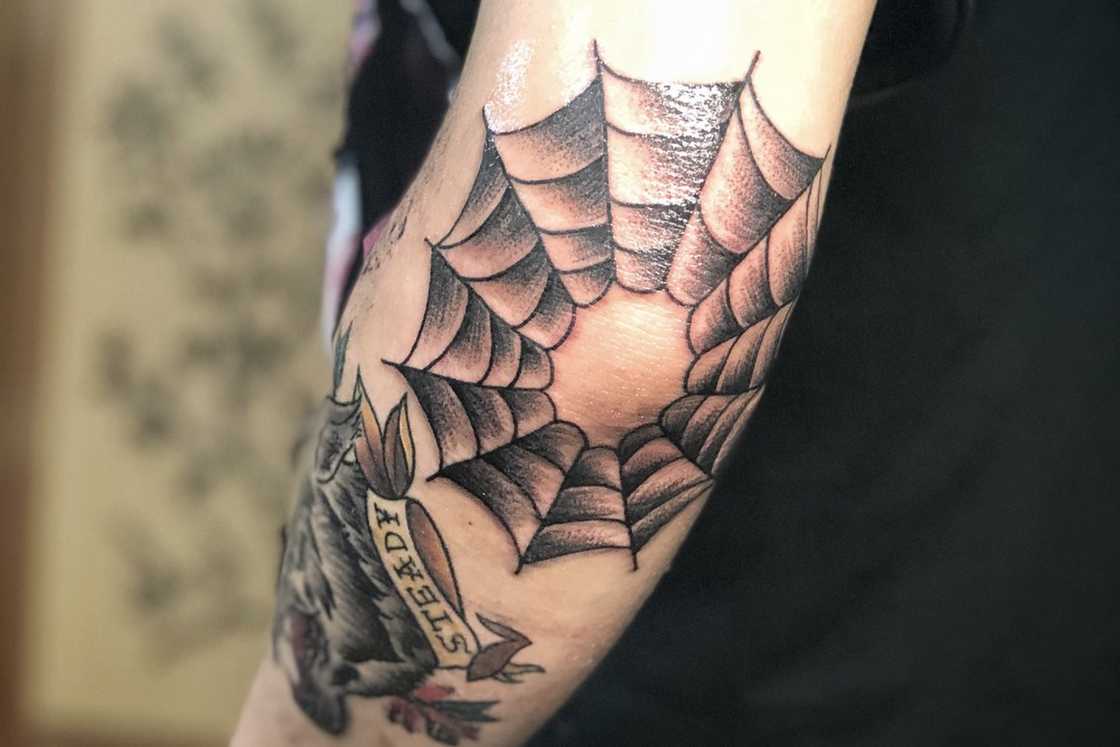Spider web tattoo looping around the elbow Spider web tattoo looping around the elbow