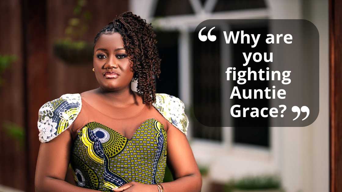 A woman in a patterned dress stands outdoors with her hands clasped in front of her.