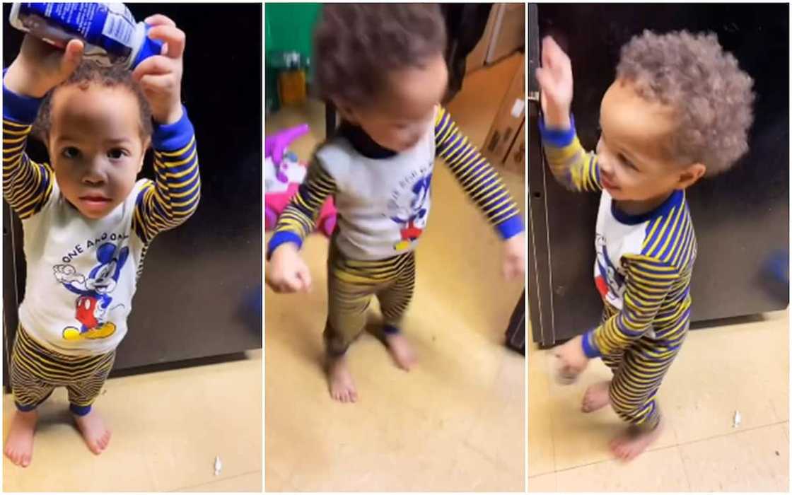 The excited kid danced with a bottle of juice in his hand. The excited kid danced with a bottle of juice in his hand.