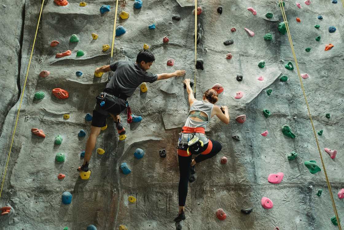 Two adults during a rock climbing activity Two adults during a rock climbing activity