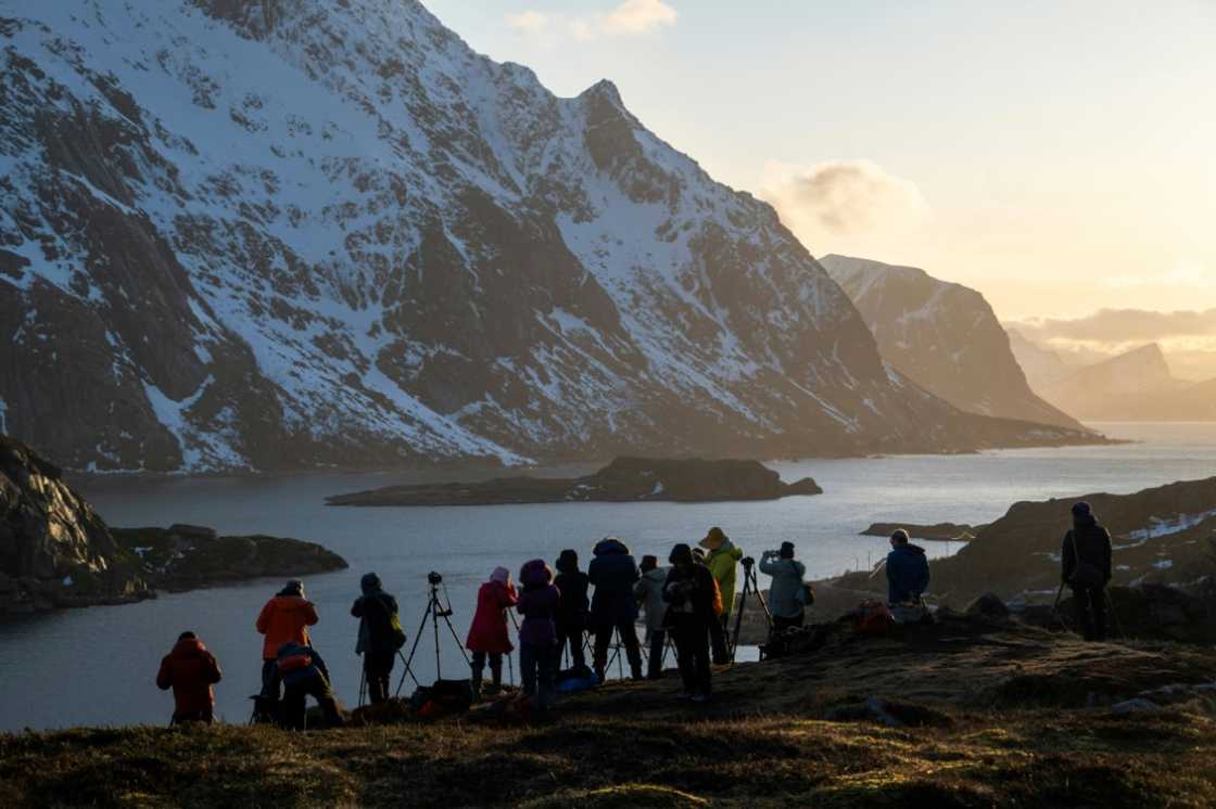 Tourists photograph a fjord in Norway's Lofoten Islands Tourists photograph a fjord in Norway's Lofoten Islands