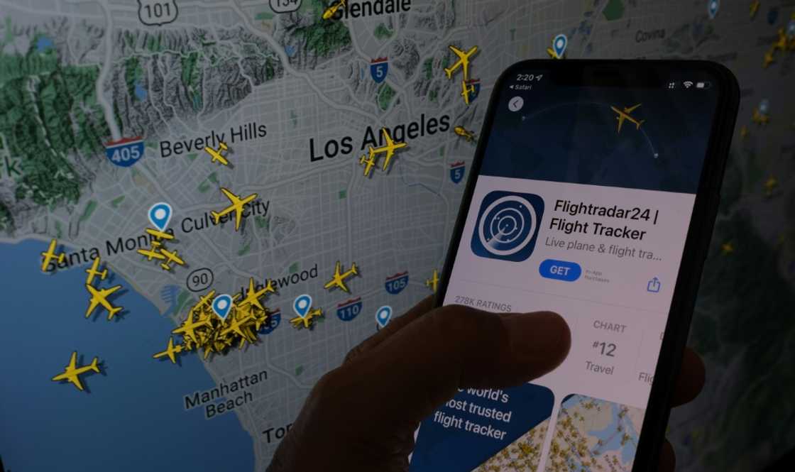 The Flightradar24 app is seen on a smartphone in front of a screen showing the live position of planes tracked by the app in the area of Los Angeles on August 5, 2022 The Flightradar24 app is seen on a smartphone in front of a screen showing the live position of planes tracked by the app in the area of Los Angeles on August 5, 2022