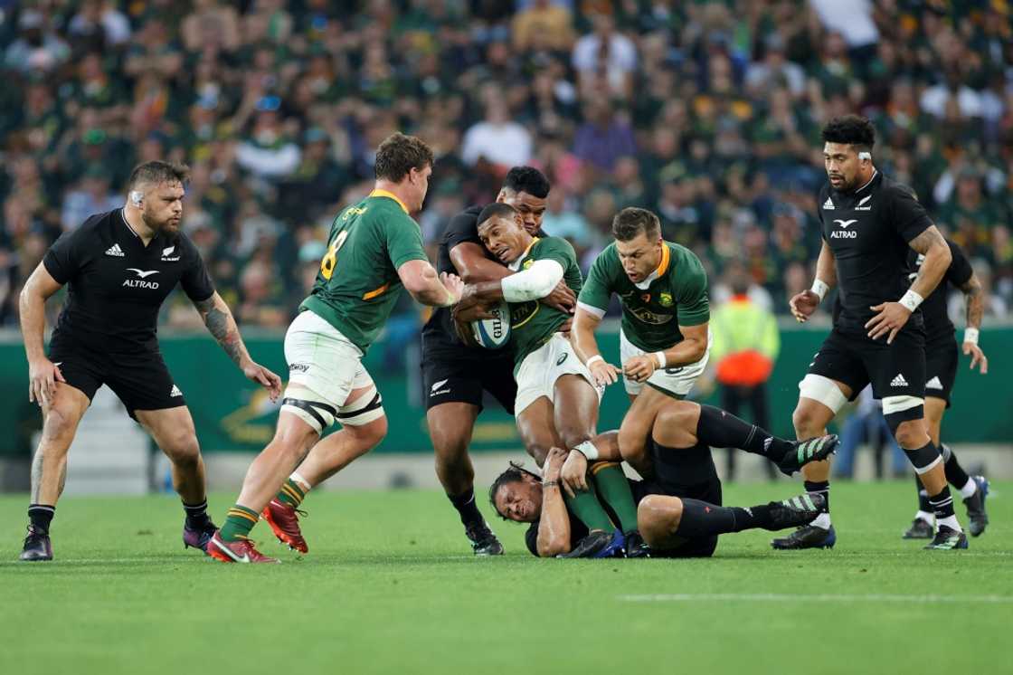South Africa's fullback Damian Willemse (C) is tackled by New Zealand's wing Caleb Clarke (bottom) and New Zealand's hooker Samisoni Taukei'aho (3rd L) during the Rugby Championship international rugby match between South Africa and New Zealand at the Mbombela Stadium in Mbombela on August 6, 2022. South Africa's fullback Damian Willemse (C) is tackled by New Zealand's wing Caleb Clarke (bottom) and New Zealand's hooker Samisoni Taukei'aho (3rd L) during the Rugby Championship international rugby match between South Africa and New Zealand at the Mbombela Stadium in Mbombela on August 6, 2022.