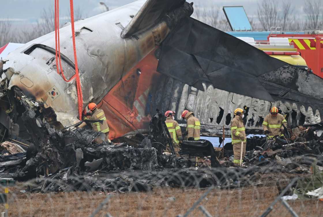 Firefighters and recovery teams work at the scene where a Jeju Air Boeing 737-800 aircraft crashed and burst into flames