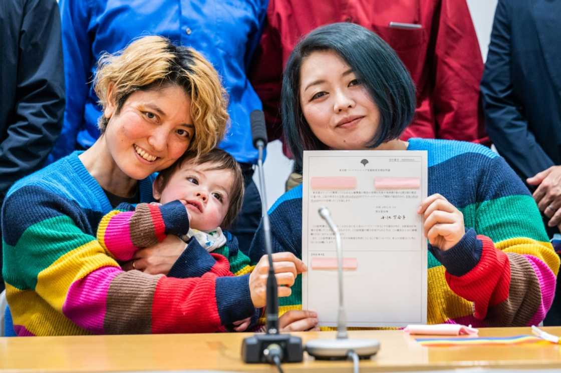Mamiko Moda (L) and her partner Satoko Nagamura, along with their son, hold a same-sex partnership certificate at a Tuesday press conference Mamiko Moda (L) and her partner Satoko Nagamura, along with their son, hold a same-sex partnership certificate at a Tuesday press conference