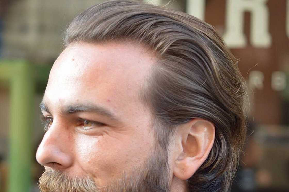 A man with combed-back waves and a beard A man with combed-back waves and a beard