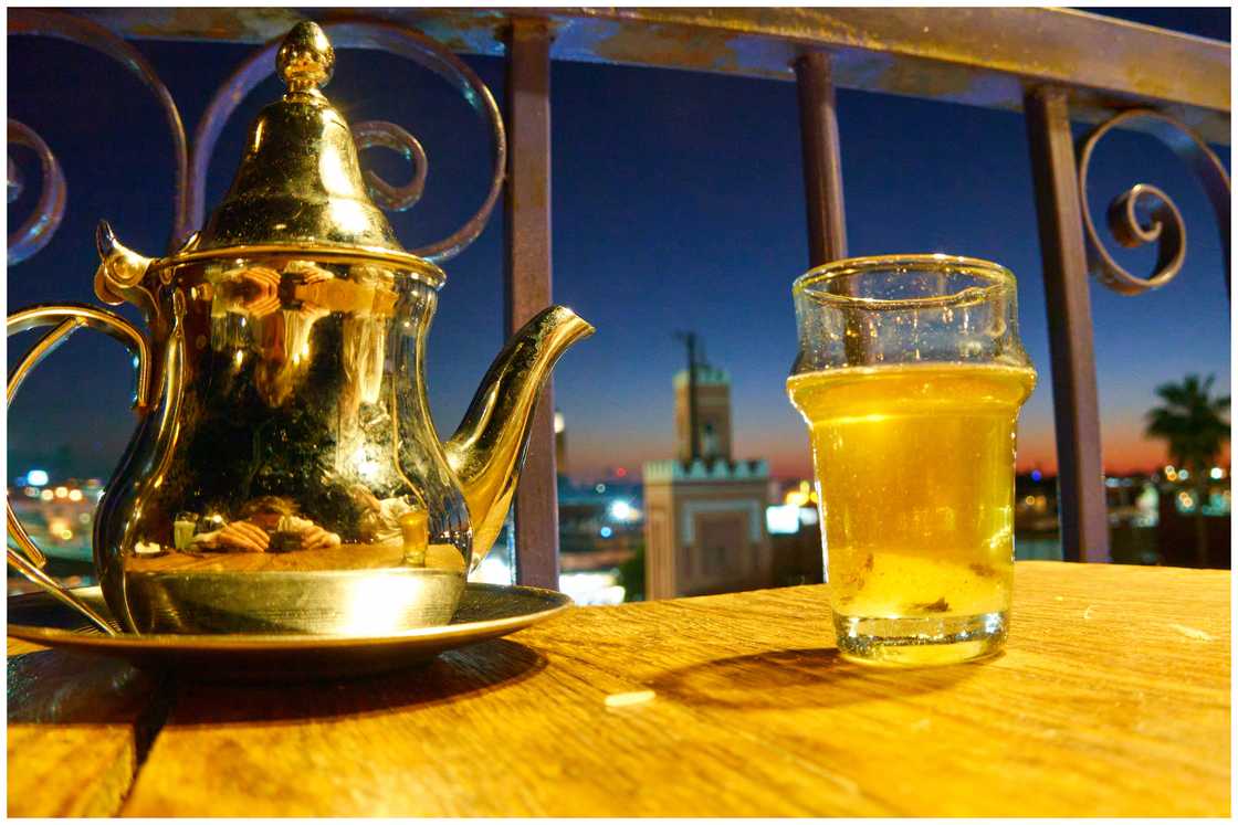 A pot and a glass of traditional mint tea at a rooftop bar A pot and a glass of traditional mint tea at a rooftop bar