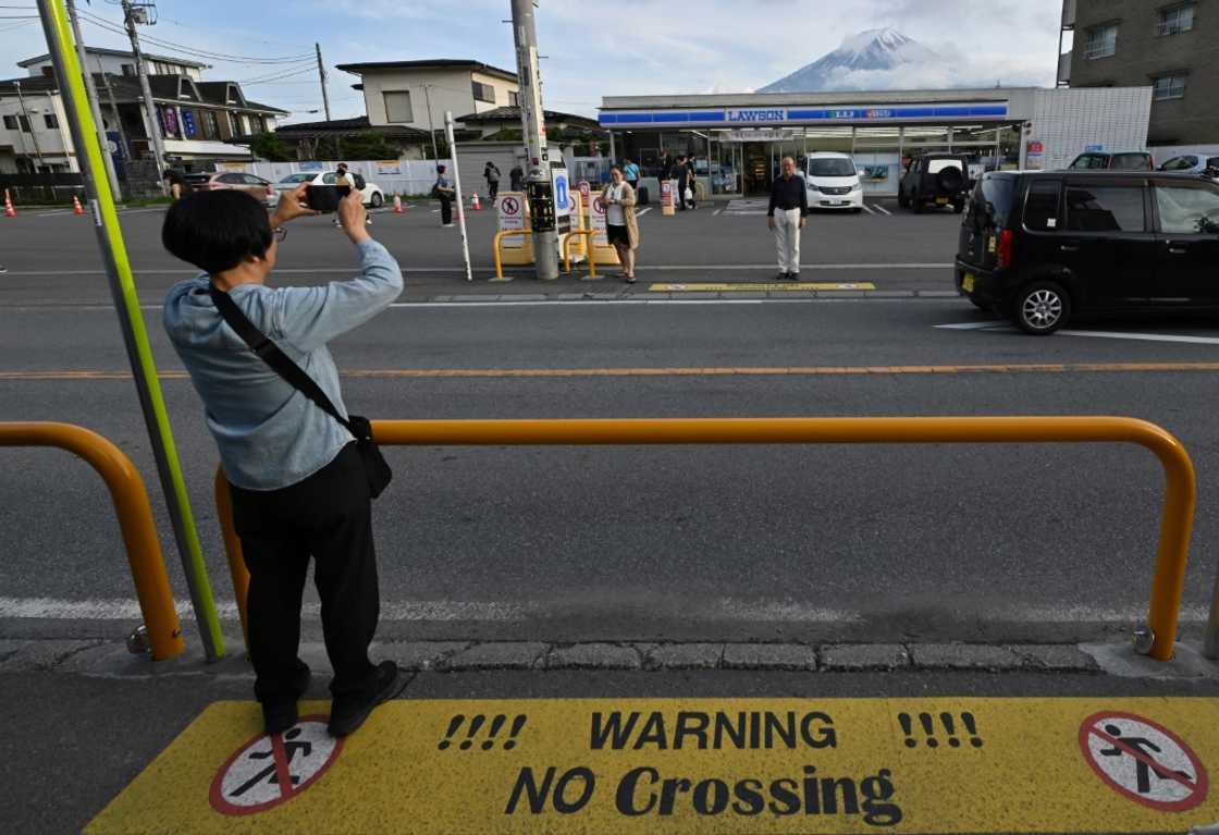 A tourist takes pictures of Mount Fuji in the town of Fujikawaguchiko, Yamanashi prefecture A tourist takes pictures of Mount Fuji in the town of Fujikawaguchiko, Yamanashi prefecture