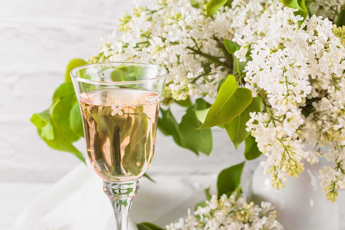 Sherry wine glass standing closer to a flower.