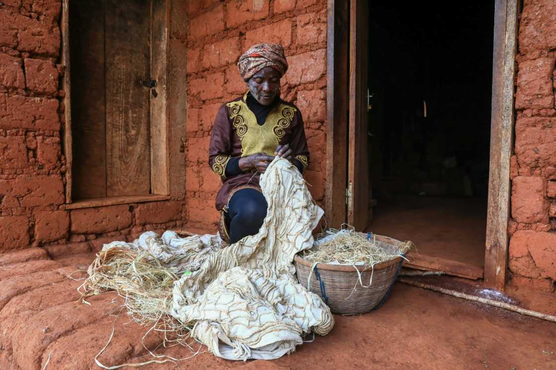 Hard work: Solange Yougo embroiders an as yet undyed piece of ndop cloth at her home in Baham