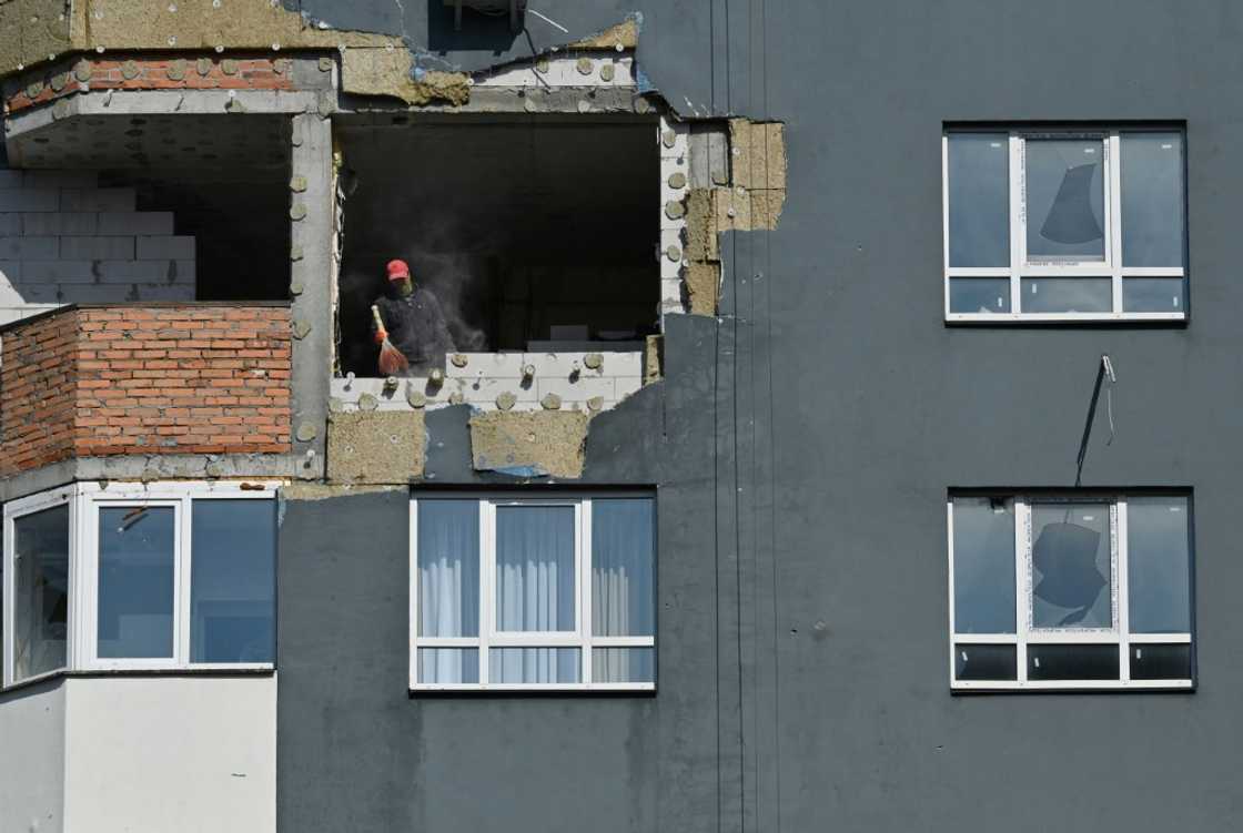 A construction worker sweeps dust from a damaged flat during repair work at an apartment block destroyed by shelling in Irpin A construction worker sweeps dust from a damaged flat during repair work at an apartment block destroyed by shelling in Irpin