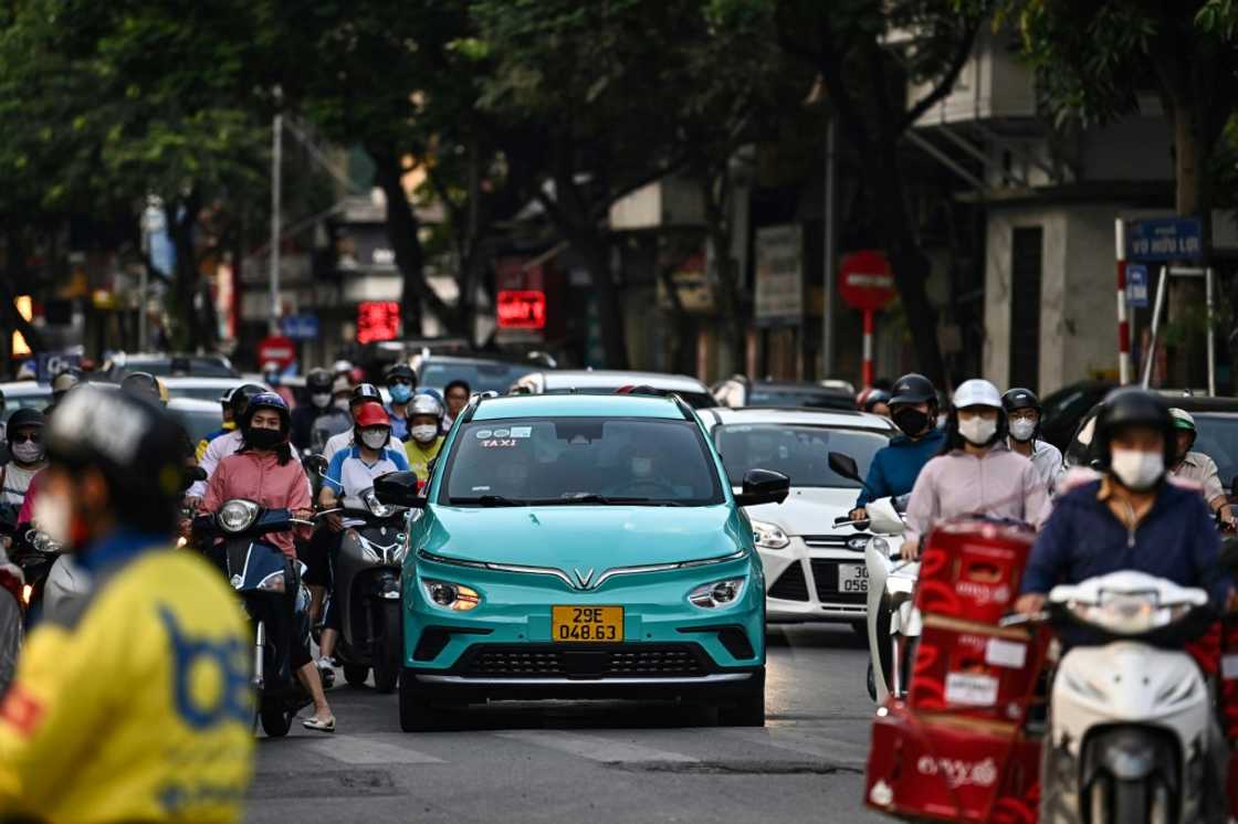 A Vinfast electric car travels down a street in Hanoi