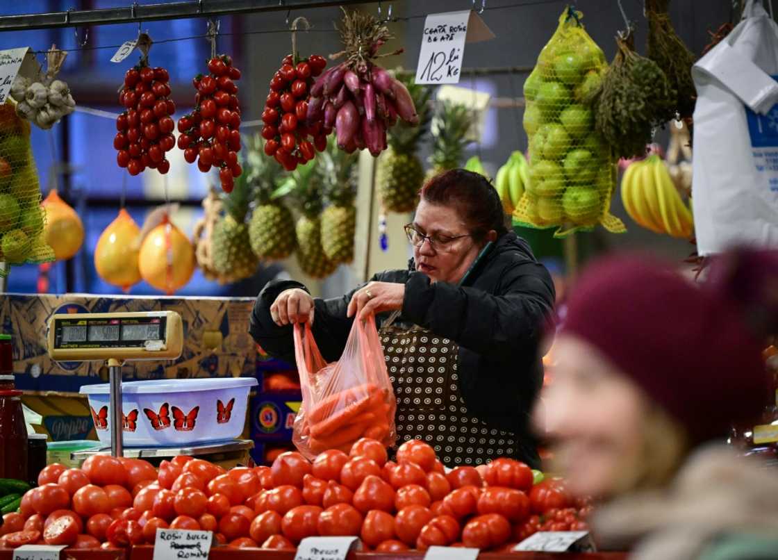 A vendor fills a bag with carrots at Piata Obor marketplace in Bucharest A vendor fills a bag with carrots at Piata Obor marketplace in Bucharest