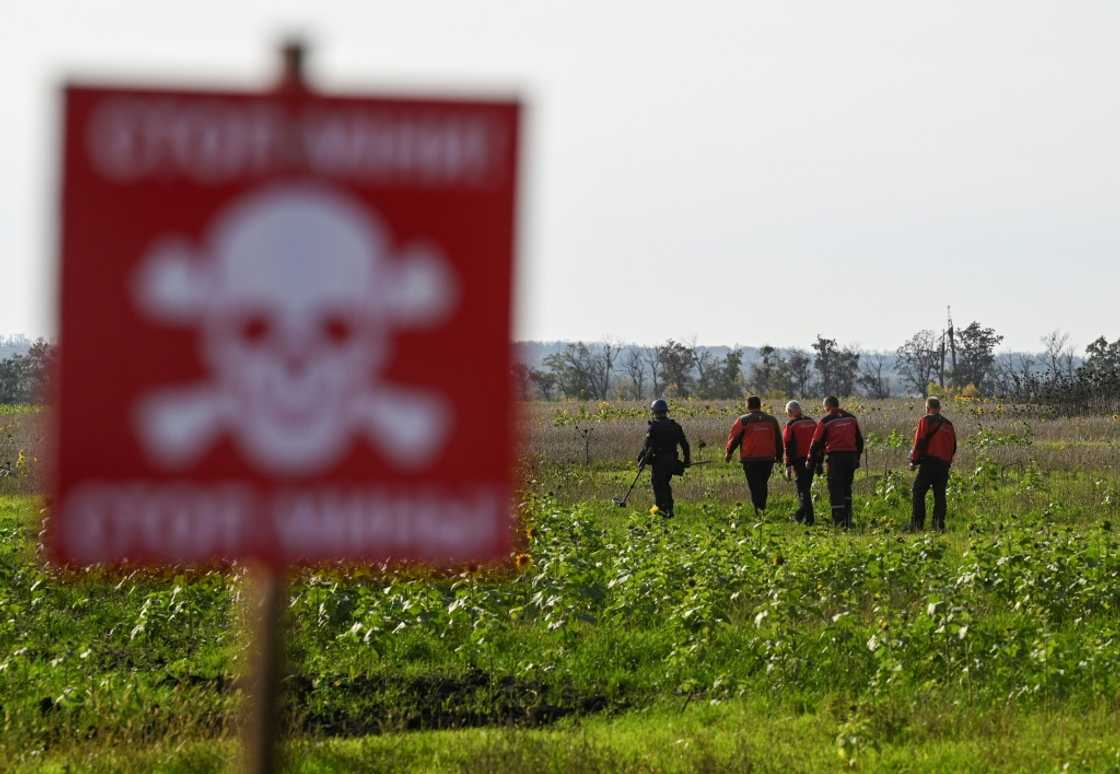 Members of a Ukrainian mine-clearing unit sweep a field near Izyum on Saturday Members of a Ukrainian mine-clearing unit sweep a field near Izyum on Saturday