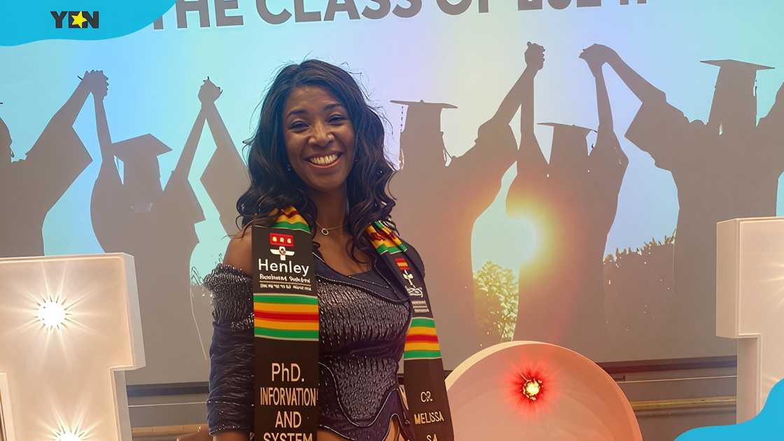 Melissa Mensah poses against a graduation banner