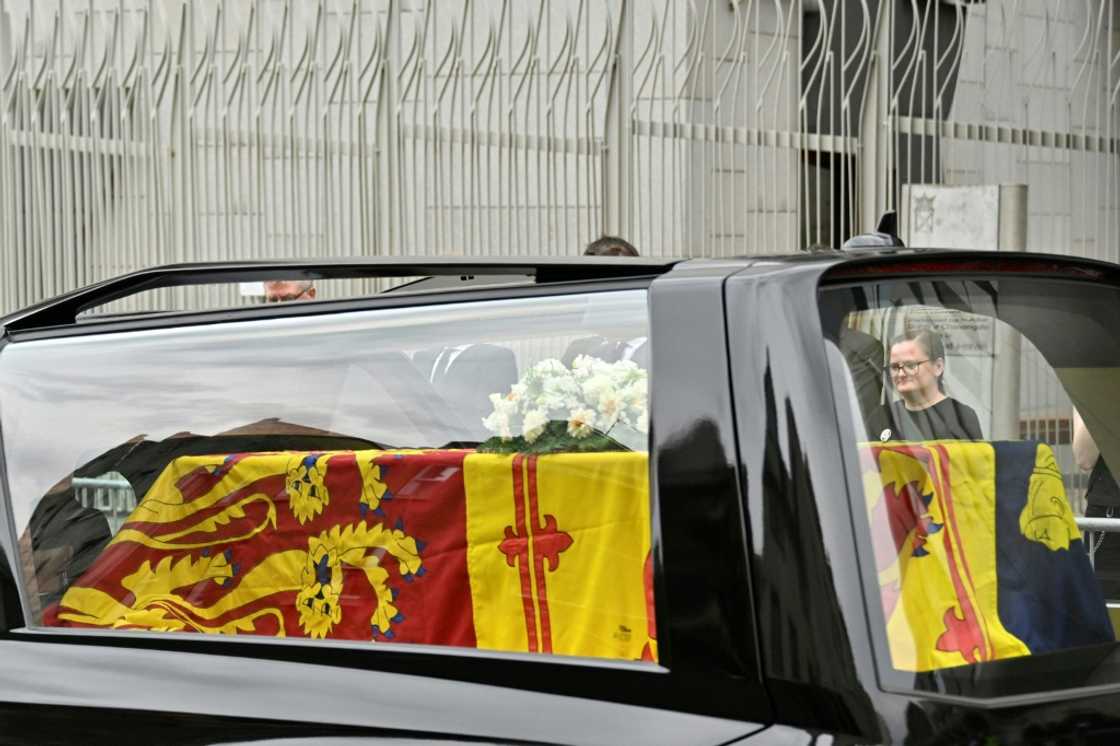 The hearse carrying the coffin of Queen Elizabeth II, draped in the Royal Standard of Scotland, is driven through Edinburgh towards the Palace of Holyroodhouse, on September 11, 2022