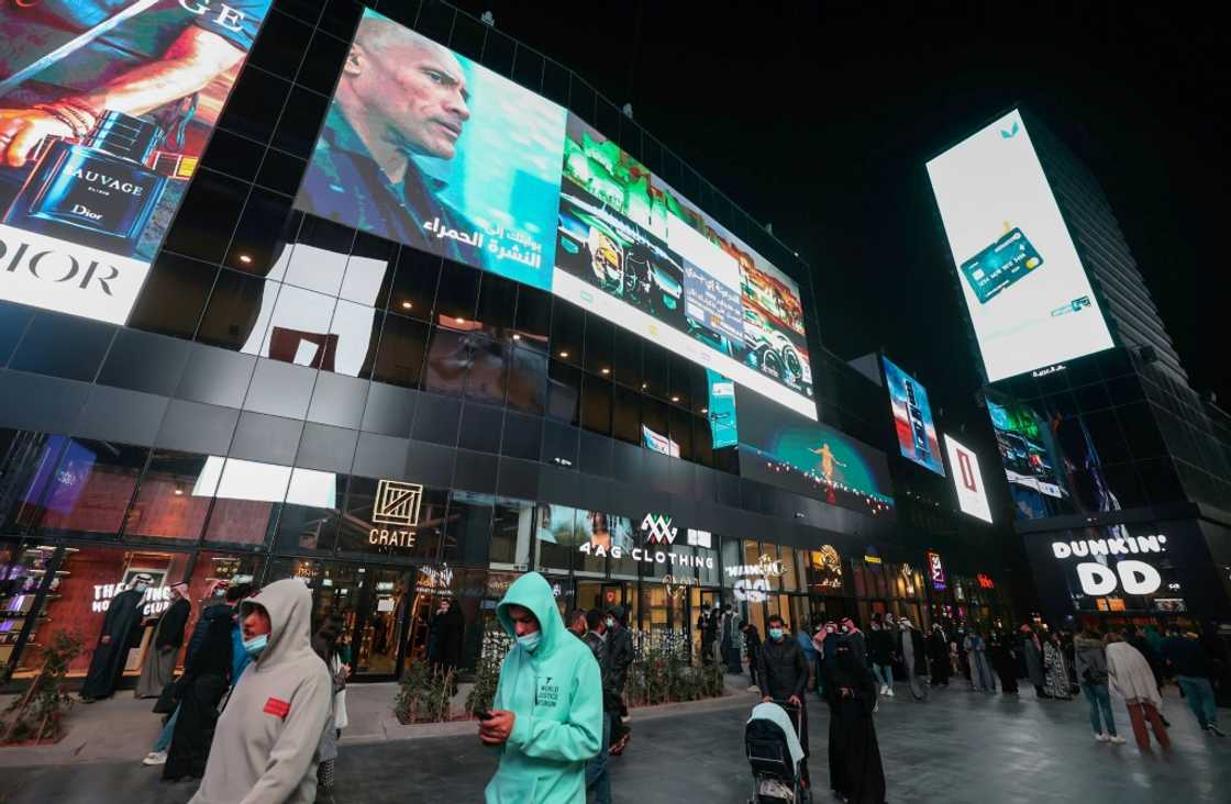 People walk beneath advertising billboards at Boulevard entertainment city in the Saudi capital Riyadh -- several analysts said the kingdom's youth are more open to ties with Israel People walk beneath advertising billboards at Boulevard entertainment city in the Saudi capital Riyadh -- several analysts said the kingdom's youth are more open to ties with Israel