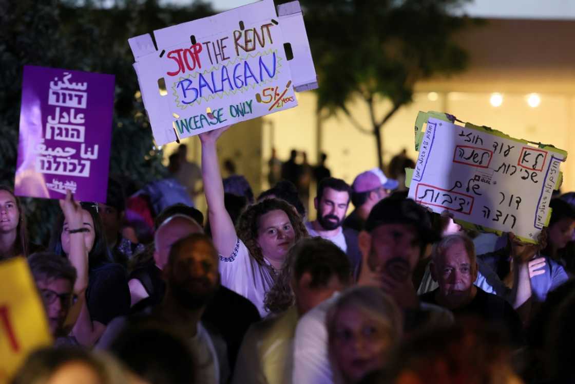 Israelis wave placards as they gather in the coastal city of Tel Aviv to demonstrate against the increase in prices in the real estate market on July 2, 2022 Israelis wave placards as they gather in the coastal city of Tel Aviv to demonstrate against the increase in prices in the real estate market on July 2, 2022