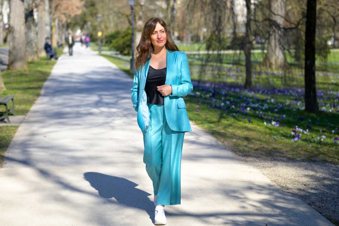 A stylish, attractive middle-aged woman in a turquoise pantsuit A stylish, attractive middle-aged woman in a turquoise pantsuit