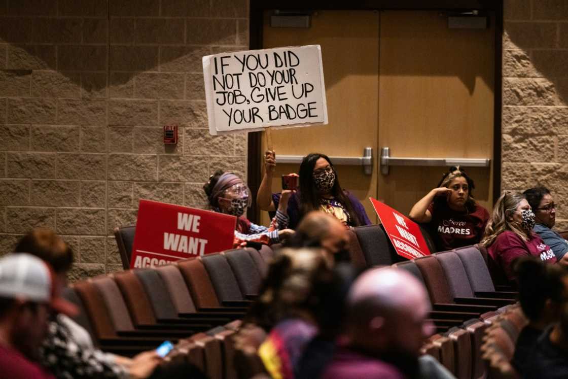 Attendees hold signs as the Uvalde Consolidated Independent School District Board holds a special meeting to consider the firing of Police Chief Pete Arredondo on August 24, 2022 in Uvalde, Texas Attendees hold signs as the Uvalde Consolidated Independent School District Board holds a special meeting to consider the firing of Police Chief Pete Arredondo on August 24, 2022 in Uvalde, Texas
